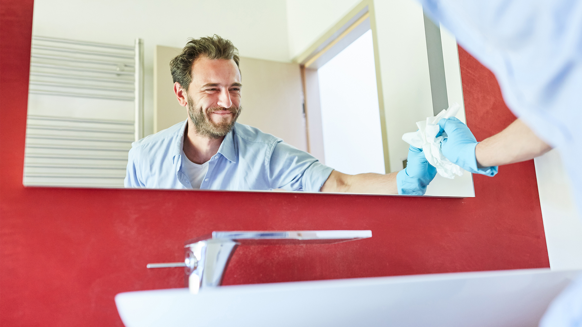 uomo pulisce lo specchio dopo aver pulito lo spazzolino da denti