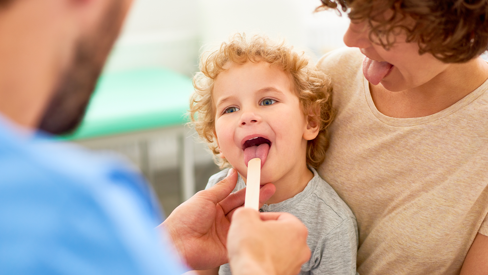 dentista visita un bimbo per spiegare ai genitori come lavare i denti ai bambini