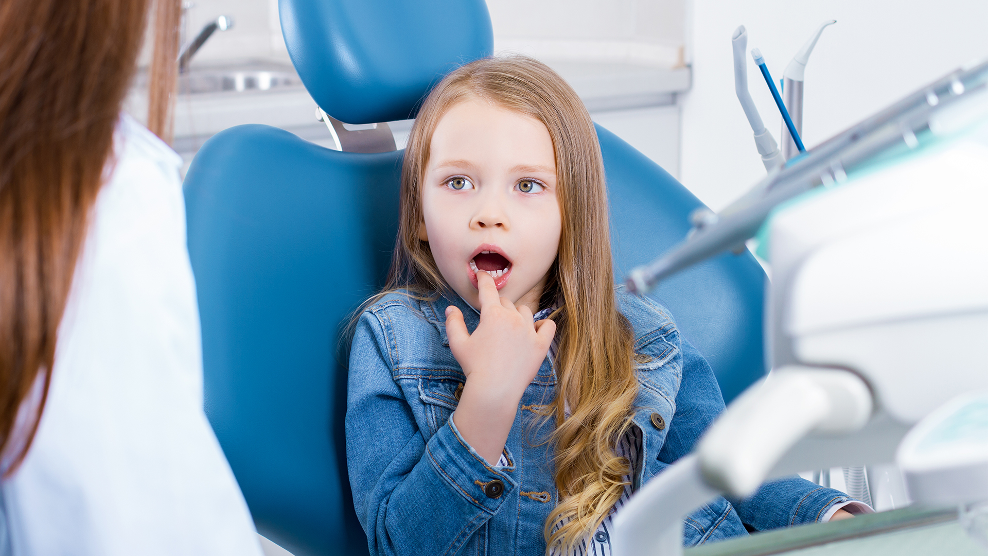 bimba mostra a dentista dente con carie al primo stadio